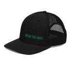 Black trucker hat with mesh back and green text on a white background