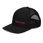 Black mesh trucker hat with pink text on a white background